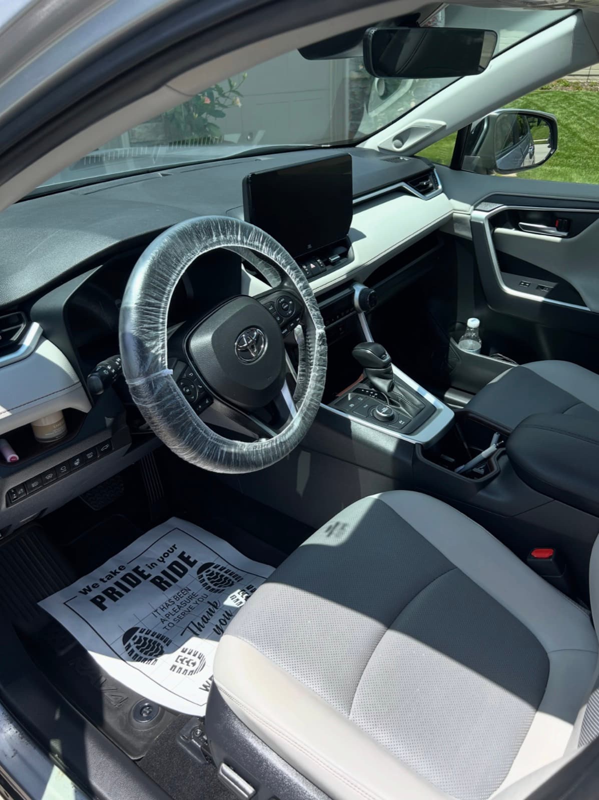 Steering wheel cover and floor protector down — interior detail in progress on a RAV4